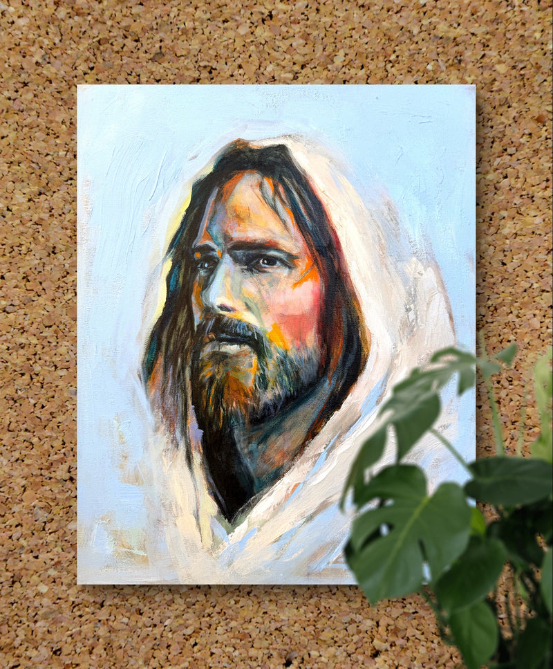 Painting of Jesus Christ on a cork board with a green plant in the foreground
